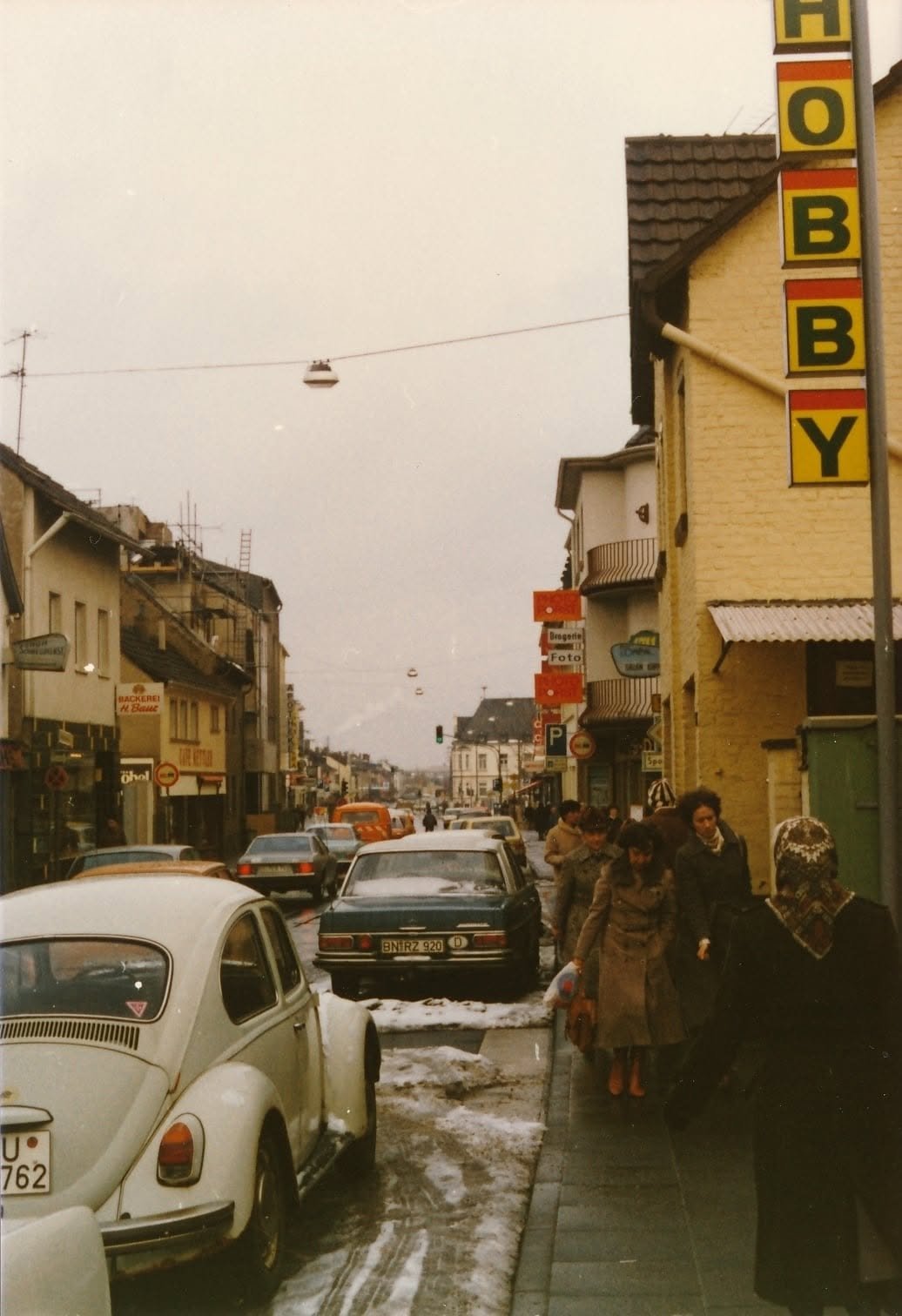Geschäftsstraße in Bonn-Duisdorf in den siebziger Jahren mit Hobbymarkt-Schild und parkenden Autos