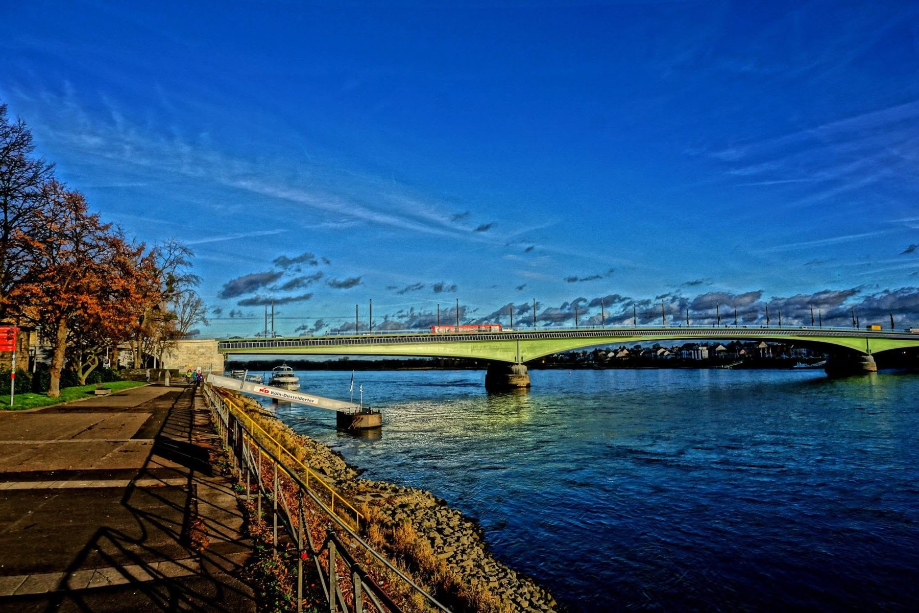 Kennedybrücke über den Rhein mit Uferweg und Schiffsanleger